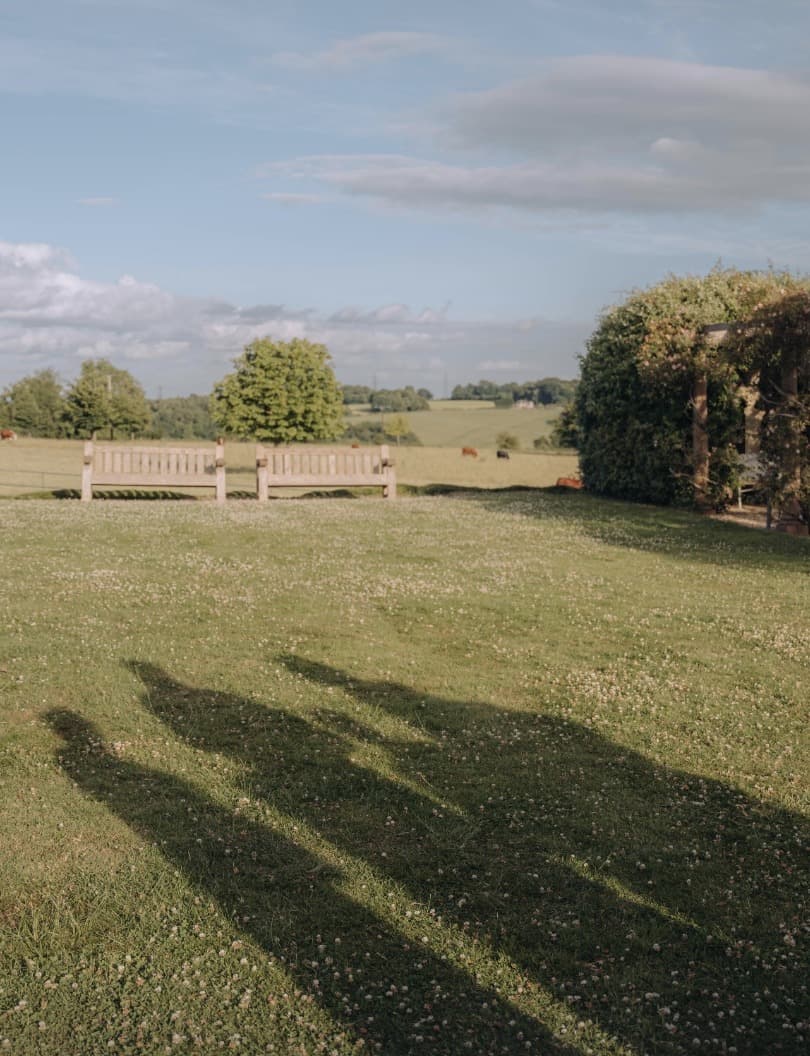 Long shadows of a family across a meadow at golden hour